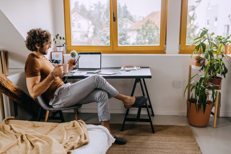 Homeowner sitting at work desk, reviewing information about his heat pump efficiency.