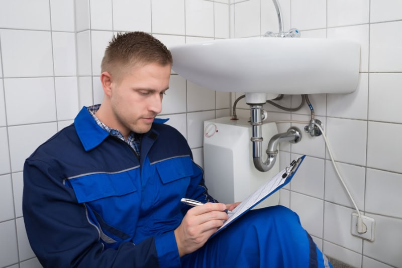 Plumber Writing On Clipboard.